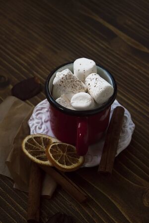 View of moody hot chocolate with delicious marshmallows and autumnal decorations on wooden background.の写真素材