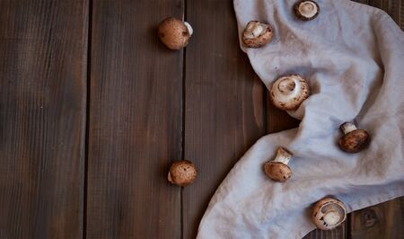 Garden-fresh champignons on crem napkin on wooden background.の写真素材