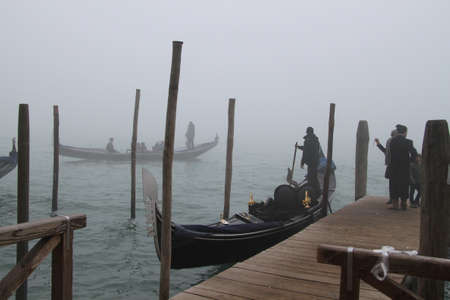 Gondolas on a canal in the fog in Veniceのeditorial素材