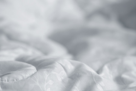 White blanket. Wrinkle messy blanket in bedroom after waking up in the morning. Bed details. Duvet and blanket, an unmade hotel bedroom with white blanket. Messy White Bed.の写真素材