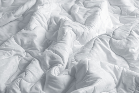 White blanket. Wrinkle messy blanket in bedroom after waking up in the morning. Bed details. Duvet and blanket, an unmade hotel bedroom with white blanket. Messy White Bed.の写真素材