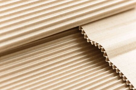 Carton or cardboard packing material. Texture of corrugated paper sheets made from cellulose. Supplies for creating boxes and packaging. Pasteboard background. Natural brown cardboard surface.の写真素材