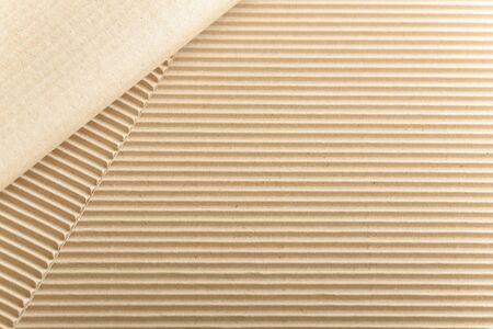 Carton or cardboard packing material. Texture of corrugated paper sheets made from cellulose. Supplies for creating boxes and packaging. Pasteboard background. Natural brown cardboard surface.の写真素材