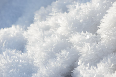 Hoarfrost background texture. Fresh ice and snow winter backdrop with snowflakes and mounds. Seasonal wallpaper. Frozen water geometrical shapes and figures. Cold weather atmospheric precipitation.の写真素材