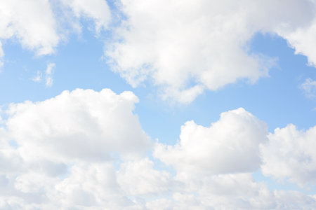 White big fluffy clouds. Natural scenic abstract background. Weather changes backdrop. Sky filled with voluminous clouds.の写真素材