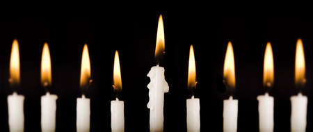 Beautiful lit hanukkah candles on black.  Super black background.  Carefully spotted and retouched.  High resolution images shot with a 100 mm macro lens. の写真素材