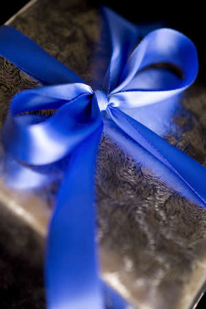 Blue Ribbon Tied in a Bow on Silver Gift.  High Resolution Image Shot with Macro Lens.  Carefully Spotted and Retouched.の写真素材