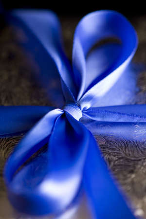Blue Ribbon Tied in a Bow on Silver Gift.  High Resolution Image Shot with Macro Lens.  Carefully Spotted and Retouched.の写真素材