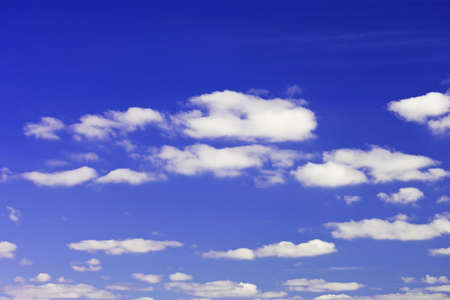 bright blue sky with white puffy cloudsの写真素材