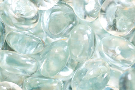 clear blue glass pebbles grouped together in background patternの写真素材