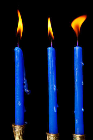 burning hanukkah candles in a menorah on black backgroundの写真素材