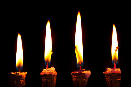 burning hanukkah candles in a menorah on black backgroundの写真素材