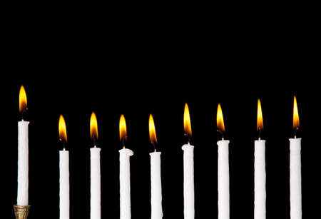 burning hanukkah candles in a menorah on black backgroundの写真素材
