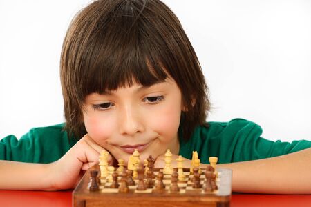 boy thinking a chess game isolated on white backgroundの写真素材