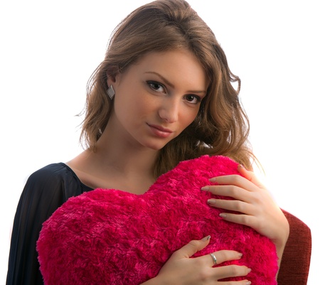 Gorgeous young blonde woman with heart shaped red pillowの写真素材