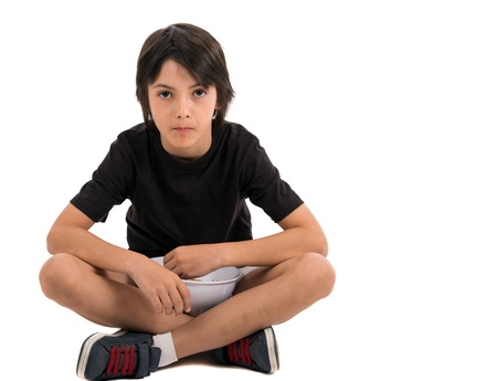 Adorable young boy sitting and eating popcorn isolated against white backgroundの写真素材
