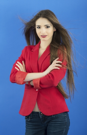 Portrait of urban business woman wearing tie, isolated on blueの写真素材