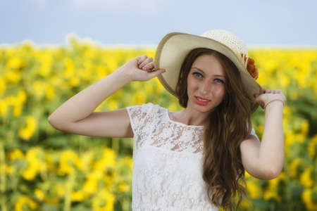 young woman on blooming sunflower field in summerの写真素材