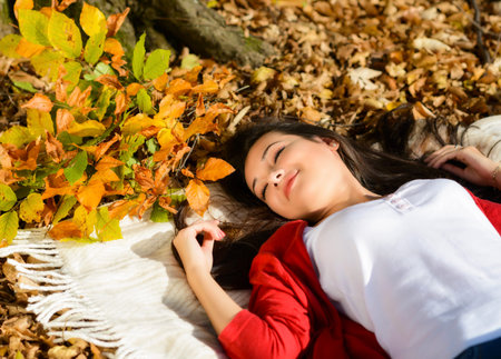 Young pretty woman relaxing in the autumn park