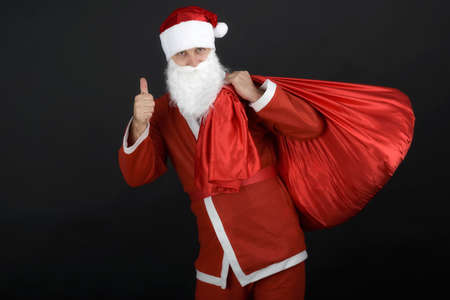 Santa Claus with christmas sack  isolated on black backgroundの写真素材