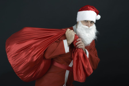 Santa Claus with christmas sack  isolated on black backgroundの写真素材