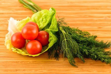 fresh green dill and tomatoes on wooden boardsの写真素材