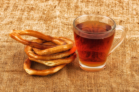 Tea in a transparent cup and bagels on a linen napkin