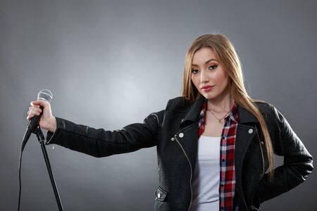 a beautiful blonde woman singing in microphoneの写真素材