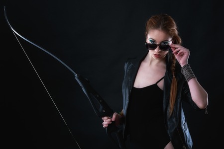 beautiful woman with bow in hand on gray backgroundの写真素材