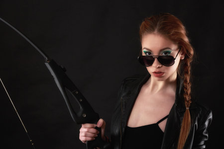 beautiful woman with bow in hand on gray backgroundの写真素材