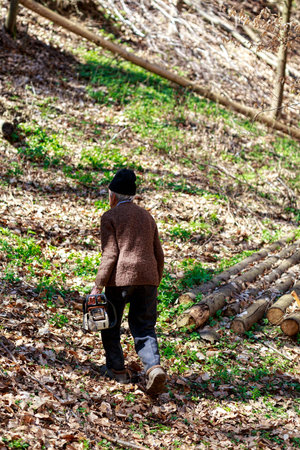 old man with a chainsaw in the forest