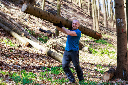 strong man carrying a tree trunk