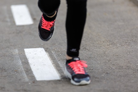 Sports background. Runner feet running on road closeup on shoe.の写真素材
