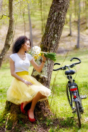 beautiful young woman with a bicycle in natureの写真素材
