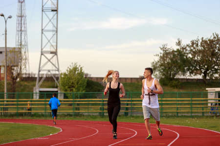 An attractive man and woman jogging on the trackの写真素材