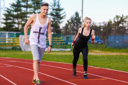 An attractive man and woman jogging on the trackの写真素材