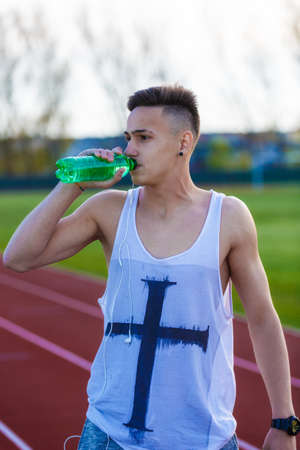 Young male latino athlete drinking waterの写真素材