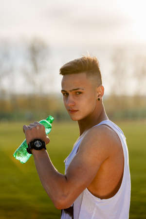 Young male latino athlete drinking waterの写真素材