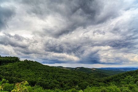 Dramatic clouds above a valley in the mountainsの写真素材
