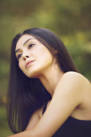 Portrait close up of young beautiful woman, on green background summer nature.の写真素材