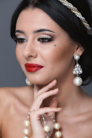 Beautiful woman with curly hair and evening make-up. Jewelry and Beauty. Fashion art photo