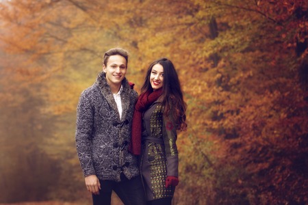 Lovers walking hand in hand in autumn parkの写真素材