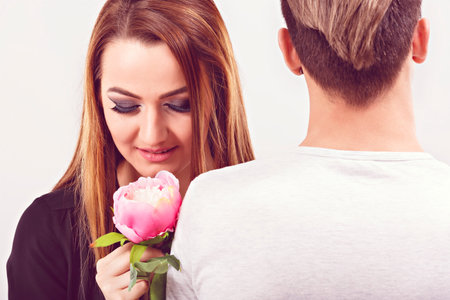 Romantic photo of beautiful couple on white background. Beautiful young woman hugging her boyfriendの写真素材