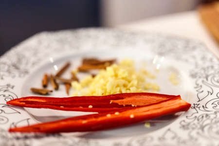 a plate with ginger cinnamon and pepper on a table in the kitchenの写真素材