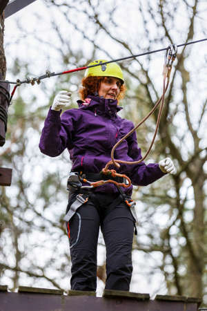 Woman on cables in an adventure park on a difficult courseの写真素材