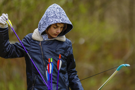 Boy archer shooting with his bow at an outdoor archery rangeの写真素材