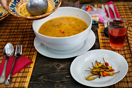 Bean soup in bowl with fresh sliced bread on napkin, on wooden table background