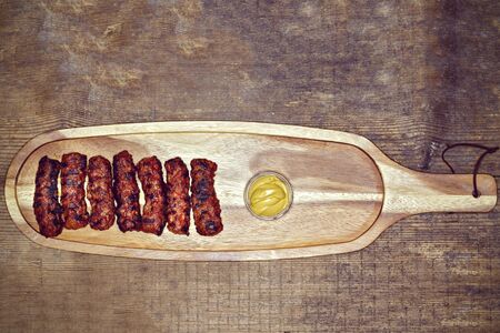 Traditional food Meat Balls "mici" on a rustic wooden table with mustardの写真素材
