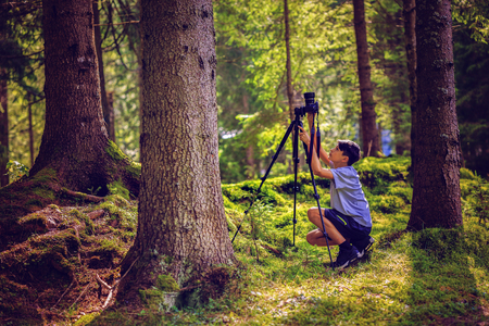 young boy takes pictures in natureの写真素材