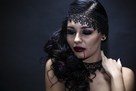 Portrait of a gorgeous brunette with a hat over black background. Halloween.の写真素材